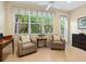 Cozy sitting area with two armchairs and a view of the backyard at 6642 Tailfeather Way, Bradenton, FL 34203
