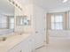 Clean bathroom with double sinks, a bathtub, and a door to another room at 7335 Fountain Palm Cir # 7335, Bradenton, FL 34203
