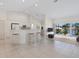 Open concept kitchen and living area with breakfast bar, white cabinetry, and access to a balcony at 7335 Fountain Palm Cir # 7335, Bradenton, FL 34203