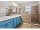 Bathroom with blue vanity, double sinks, large mirror, and walk-in shower at 8133 Miramar Way # 201, Lakewood Ranch, FL 34202