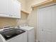 Laundry room with washer, dryer, and overhead storage at 8133 Miramar Way # 201, Lakewood Ranch, FL 34202