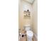Small half bathroom with toilet and wall-mounted shelving at 118 Creek Se Dr, Port Charlotte, FL 33952