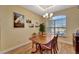 Formal dining room with wood table and chairs, hardwood floors, and natural light at 118 Creek Se Dr, Port Charlotte, FL 33952