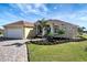Well-maintained house featuring a paver driveway and lush landscaping at 118 Creek Se Dr, Port Charlotte, FL 33952