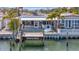 Waterfront home featuring a private dock, lush landscaping, and serene water views, perfect for relaxation at 19 Seaside Ct, Holmes Beach, FL 34217