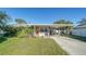 Updated Florida bungalow features a carport and a lush lawn at 2111 Outer Dr, Sarasota, FL 34231