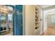 Hallway with built-in shelves and teal door at 2111 Outer Dr, Sarasota, FL 34231