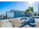Charming waterfront home featuring a vibrant turquoise exterior and well-maintained landscaping at 23 Seaside Ct, Holmes Beach, FL 34217