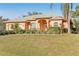 Tan house with gray roof, two-car garage, and well-maintained yard at 3623 Monday Ter, North Port, FL 34286