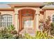 Inviting front entrance with pillars, lush landscaping, and a decorative light fixture at 3623 Monday Ter, North Port, FL 34286