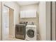 Well-lit laundry room with washer, dryer, and cabinets at 3623 Monday Ter, North Port, FL 34286