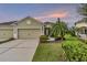 Two-car garage, lush landscaping, and inviting front walkway at 4004 Wildgrass Pl, Parrish, FL 34219