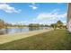 Spacious backyard with a lake view, lush green grass, and palm trees at 4209 Cascade Falls Dr, Sarasota, FL 34243