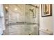 Bathroom with shower and grab bars, marble-tiled walls at 601 Gulf N Dr # 209, Bradenton Beach, FL 34217