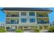 Two-story building with balconies, parking, and tropical landscaping at 601 Gulf N Dr # 209, Bradenton Beach, FL 34217
