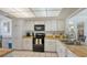 White kitchen cabinets, black appliances, and wood countertops at 601 Gulf N Dr # 209, Bradenton Beach, FL 34217