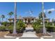 Community clubhouse with palm trees and manicured lawn at 918 River Basin Ct # 101A, Bradenton, FL 34212