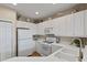 White kitchen with stainless steel appliances and double sink at 918 River Basin Ct # 101A, Bradenton, FL 34212