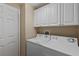 Convenient laundry room with washer, dryer, and overhead cabinets at 918 River Basin Ct # 101A, Bradenton, FL 34212