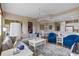 Bright living room with sectional sofa, blue armchairs, and a view to the kitchen at 918 River Basin Ct # 101A, Bradenton, FL 34212
