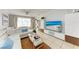 Living room features white sectional sofa and large TV at 115 Tyler Dr # 203, Sarasota, FL 34236