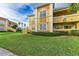 Side view of a yellow two-story building with landscaping at 1195 Villagio Cir # 201, Sarasota, FL 34237