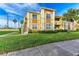 Building exterior showcasing a yellow two-story building with landscaping and walkway at 1195 Villagio Cir # 201, Sarasota, FL 34237