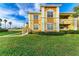 Two story yellow building with stairs and landscaping at 1195 Villagio Cir # 201, Sarasota, FL 34237