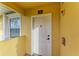 White front door with welcome mat and yellow building exterior at 1195 Villagio Cir # 201, Sarasota, FL 34237