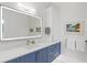 Modern bathroom with blue vanity, large mirror, and white countertop at 1335 2Nd St # 301, Sarasota, FL 34236