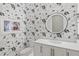 Stylish powder room with a round mirror and floral wallpaper at 1335 2Nd St # 301, Sarasota, FL 34236