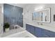 Spa-like bathroom with herringbone tile shower and blue vanity at 1335 2Nd St # 301, Sarasota, FL 34236