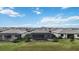 Aerial view of three homes with pools and screened enclosures, located on a lake at 15344 Serene Shores Loop, Bradenton, FL 34211