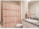 Bathroom with shower/tub combo, granite countertop, and ruffled shower curtain at 17921 Canopy Pl, Bradenton, FL 34211