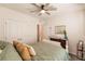 Guest bedroom with queen bed, ceiling fan, and access to hallway at 17921 Canopy Pl, Bradenton, FL 34211