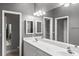 A well-lit bathroom provides a double sink vanity with a large mirror and updated fixtures at 2063 Lynx Run, North Port, FL 34288