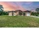 Beautiful home with stone accents and a large yard at sunset at 220 Ciboa Ave, North Port, FL 34287