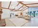 Open living space with sectional sofa, large windows, and exposed beams at 220 Ciboa Ave, North Port, FL 34287