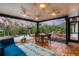 Relaxing screened porch with wood tile flooring, outdoor seating, and tranquil garden views at 220 Ciboa Ave, North Port, FL 34287