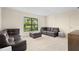 Cozy living room with dark leather couches and a large window at 4927 Windsor Park, Sarasota, FL 34235