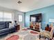 Comfortable living room featuring tile flooring, stylish furniture, and an entertainment center at 6175 Holbrook St, Englewood, FL 34224