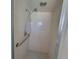 Walk-in shower with grab bar and tiled walls at 1732 Boca Raton Ct, Punta Gorda, FL 33950