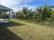 Large backyard with lush tropical landscaping and a covered patio at 378 Rallus Rd, Venice, FL 34293