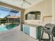 Outdoor kitchen with a built-in grill, sink, and mini-fridge at 448 Park Trace Blvd, Osprey, FL 34229