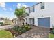 Two-story townhome with blue garage door and landscaped front yard at 5413 Tripoli Dr, Palmetto, FL 34221