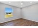 Well-lit bedroom featuring wood-look floors and a large window at 6415 Coliseum Blvd, Port Charlotte, FL 33981