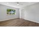 Spacious bedroom with large window, wood-look floors, and ceiling fan at 6415 Coliseum Blvd, Port Charlotte, FL 33981
