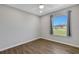 Bedroom with wood-look floors and large window at 6415 Coliseum Blvd, Port Charlotte, FL 33981