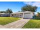 Newly built house with a driveway, lawn, and a partial view of the neighborhood at 6415 Coliseum Blvd, Port Charlotte, FL 33981