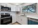 Modern kitchen with white cabinets and stainless steel appliances at 6415 Coliseum Blvd, Port Charlotte, FL 33981